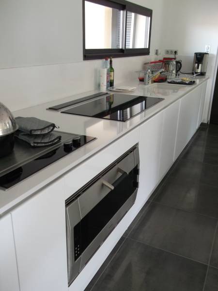 Réalisation d'une cuisine sans poignée laqué blanc haut de gamme sur Rochefort du Gard, linéair mural et zone de cuisson
