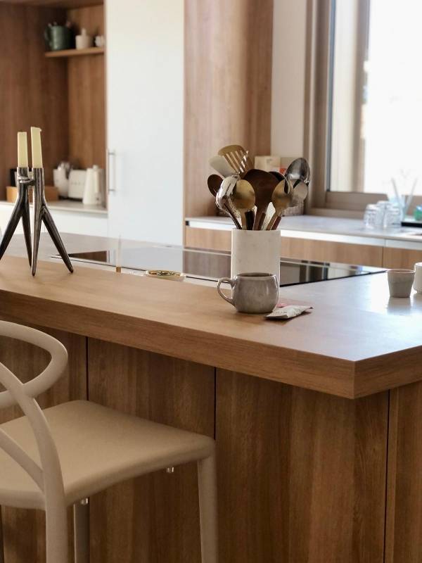 Concevoir une cuisine haut de gamme en bois naturel avec plan de travail structuré et prises intégrées à Nîmes