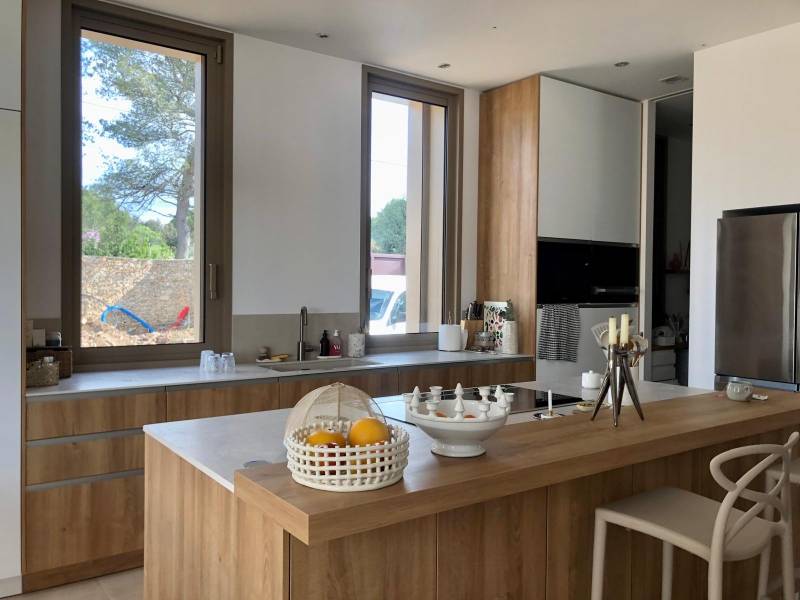 Concevoir une cuisine haut de gamme en bois naturel avec plan de travail structuré et prises intégrées à Nîmes