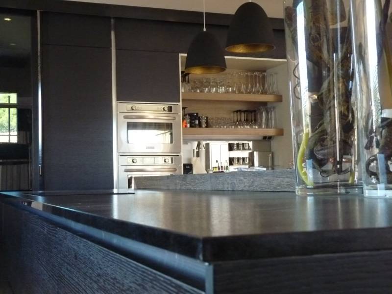 cuisine avec plan de travail en granit haut de gamme façades chêne teinté noir et électroménagers inox sur Nîmes dans le Gard