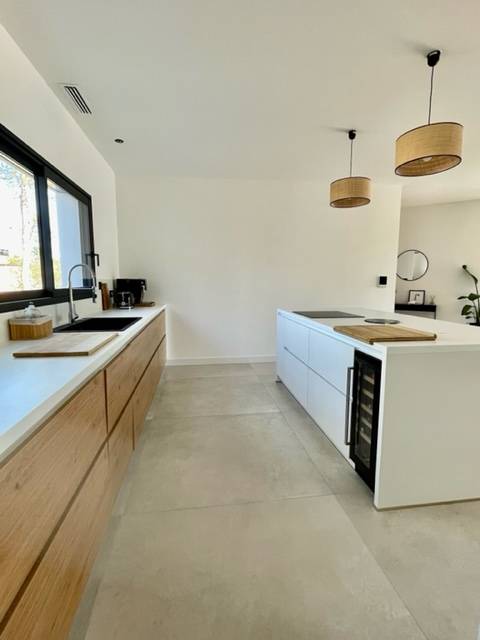 cuisine blanche et bois naturel avec un îlot central moderne installé chez notre cliente vue intérieure à Nîmes près de Montpellier