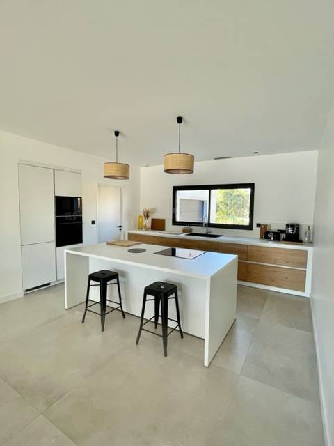 cuisine blanche et bois naturel avec un îlot central moderne installé chez notre cliente à Nîmes près de Montpellier