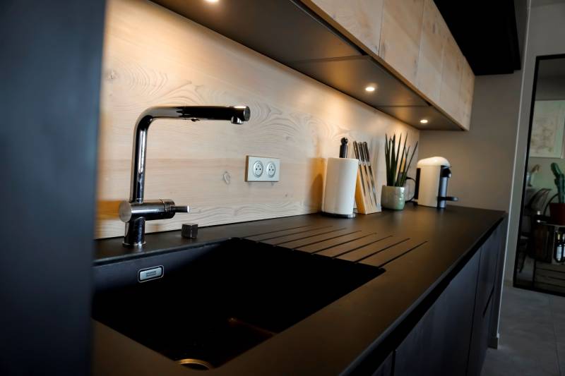 Cuisine noire et bois massif installée chez des clients près d'Uzès pour une décoration chic et moderne