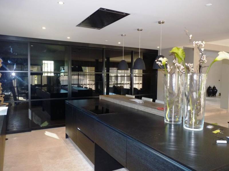 cuisine avec plan de travail en granit haut de gamme façades chêne teinté noir et hotte de plafond sur Nîmes dans le Gard